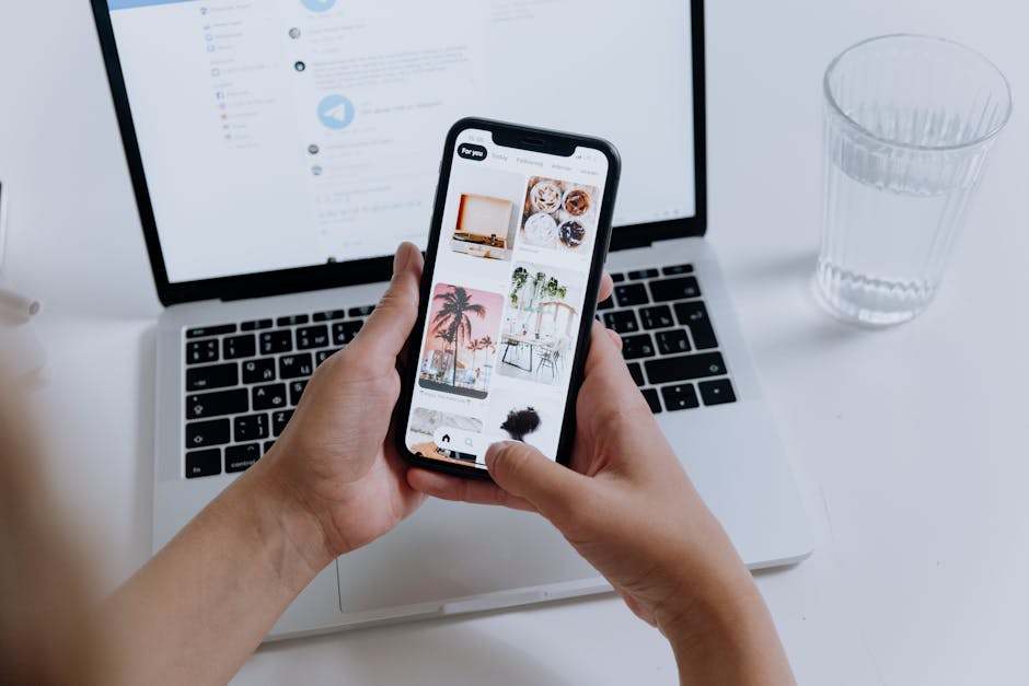 Browsing lifestyle inspiration on smartphone in modern, minimalist work-from-home setup.