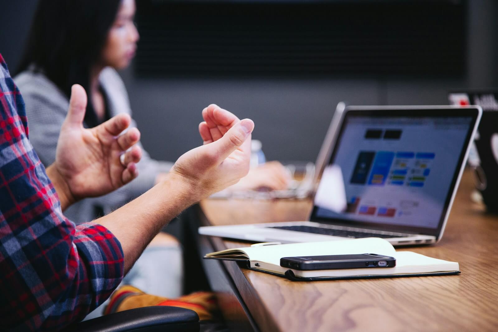 Engaging Office Meeting: Ideas in Motion Modern office meeting with dynamic hand gestures around a conference table.