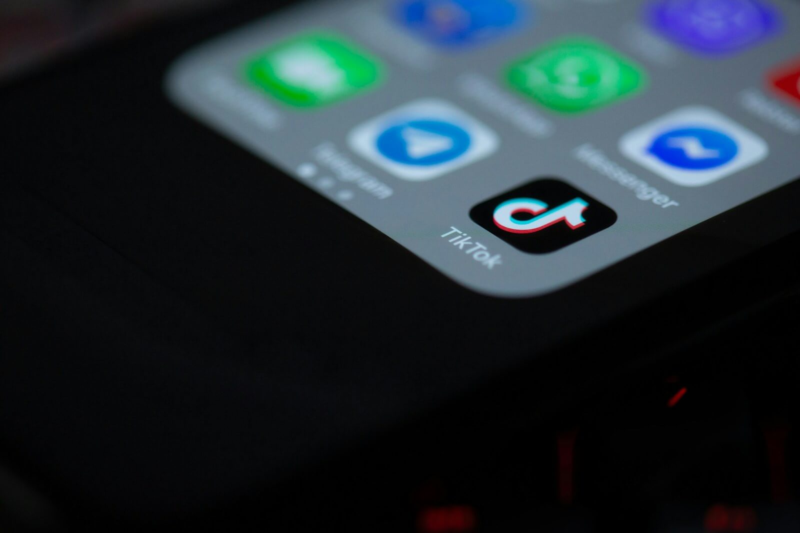 Close-up of smartphone screen with prominent TikTok icon among other app icons.